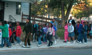 photograph of students walking with their parents and teachers